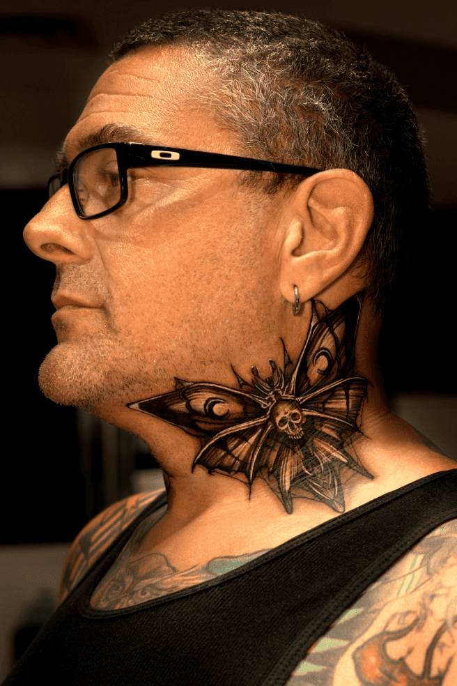 Death's-head hawkmoth spread across the side of the neck, black and grey realism