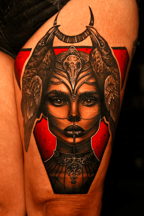 Woman in a raven-skull headdress flanked by ravens, colour thigh piece on a red background